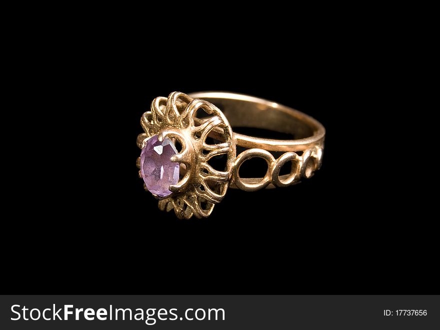 The Golden Ring with amethyst, is isolated on a black background