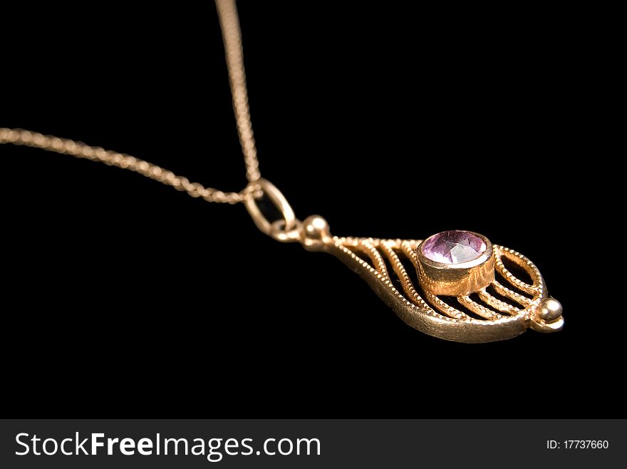 Gold coulomb with amethyst, is isolated on a black background