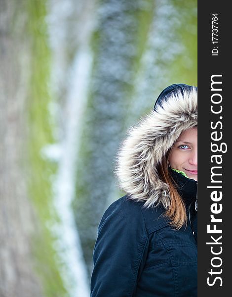 Pretty young woman outdoors in a prk on a snowy winter day (color toned image; shallow DOF)