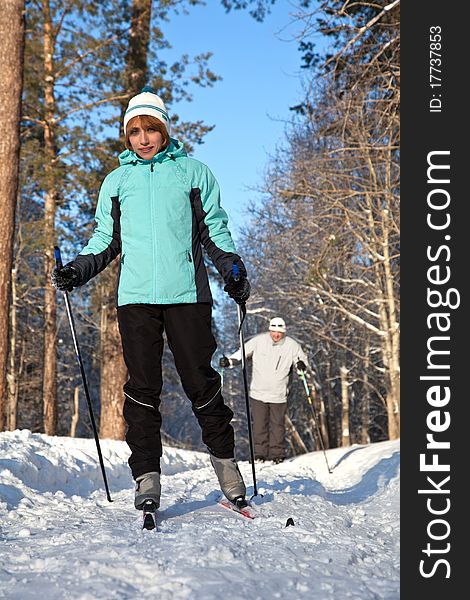 Man and woman walking on ski in winter forest