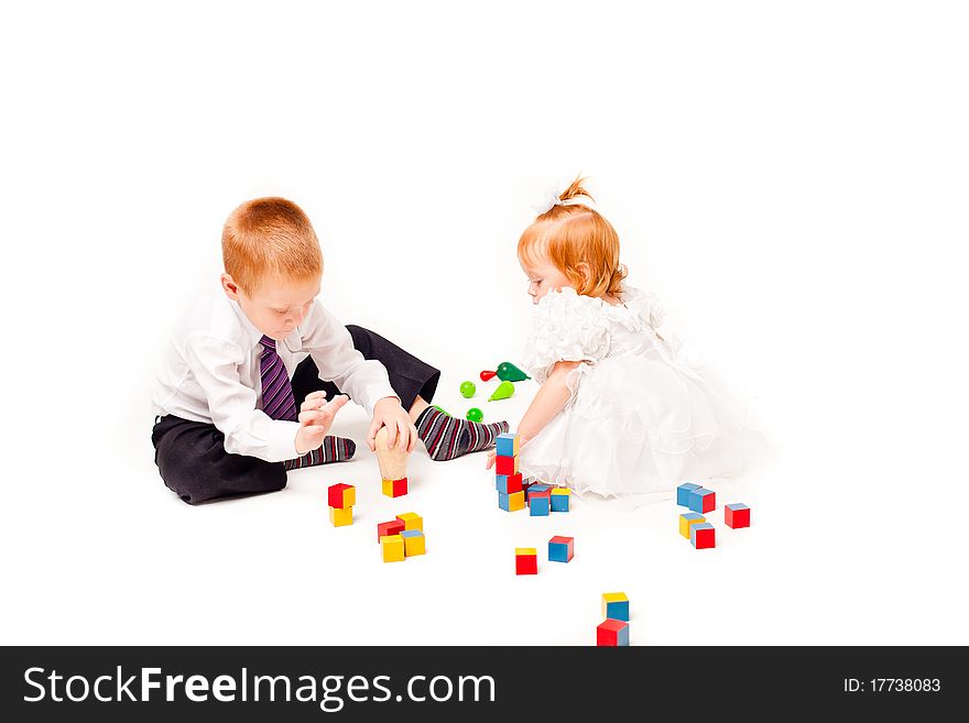 A pigeon pair play with blocks on a white background