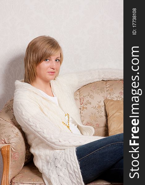 Young woman sits on a sofa