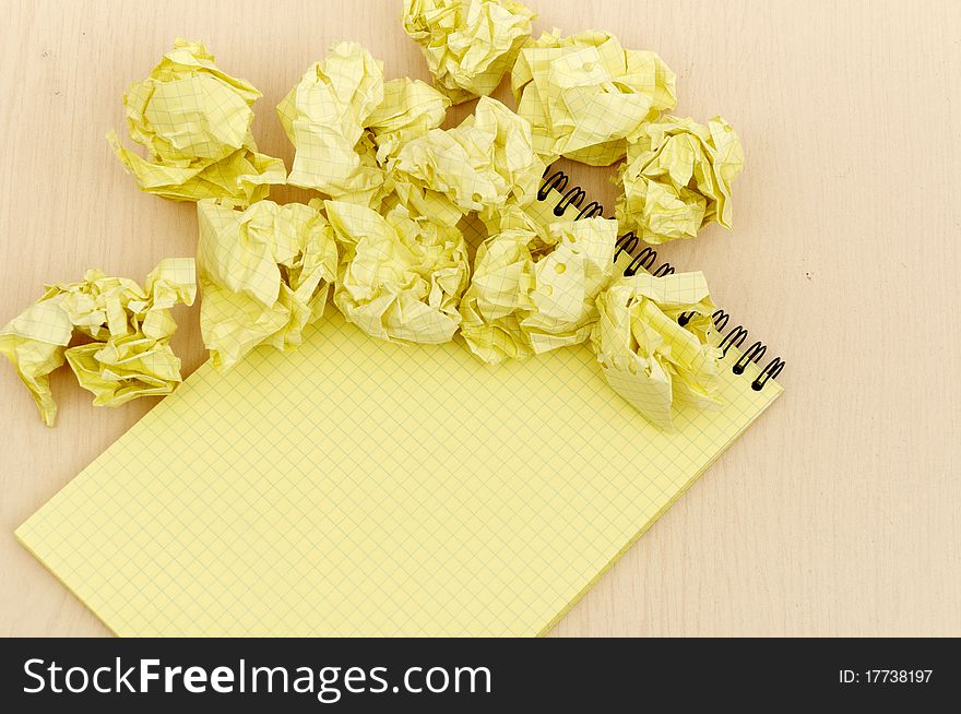 Notebook and crumpled paper on wooden table