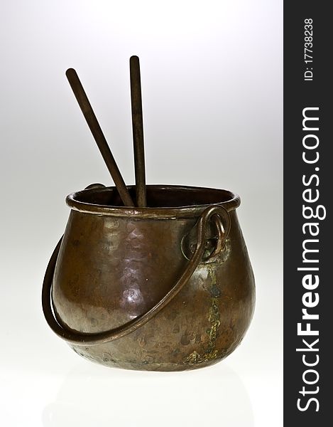 Old copper pot with two chopsticks on white. Old copper pot with two chopsticks on white