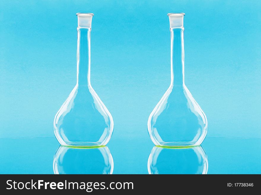 Two laboratory chemical flasks on a blue background