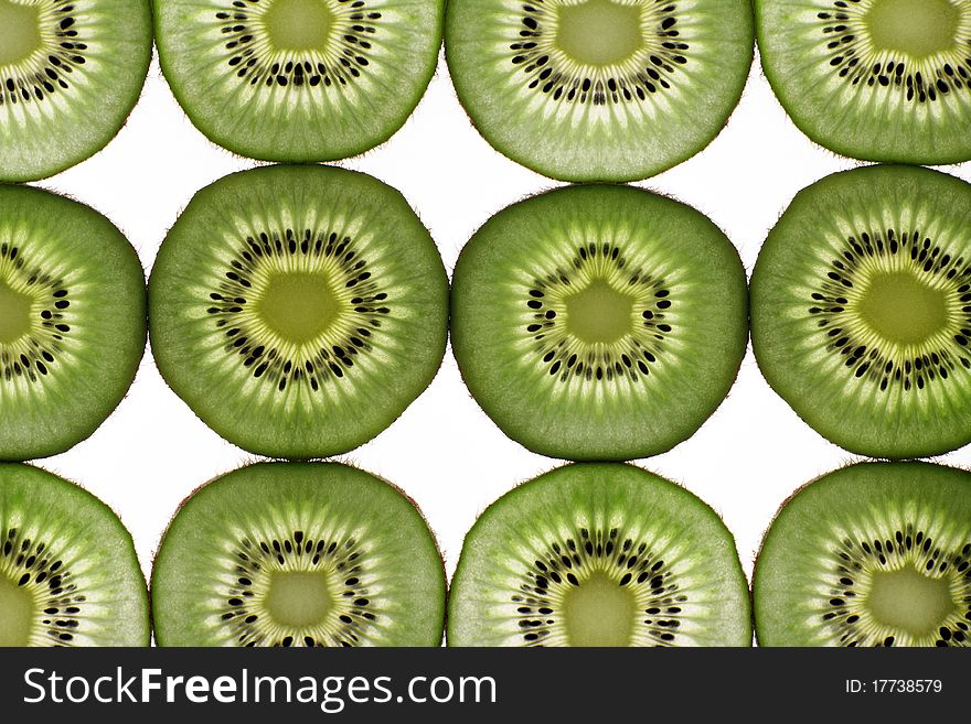 Twelve segments of a kiwi fruit are isolated on a white background