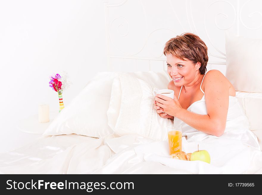 Beatiful woman having breakfast in white bed. Beatiful woman having breakfast in white bed