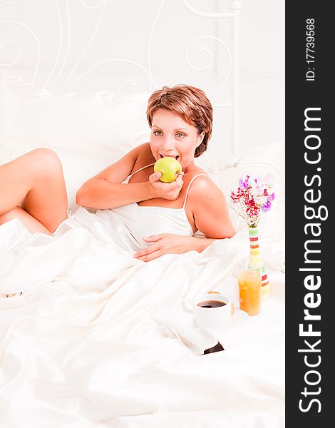 Beatiful woman having breakfast in white bed. Beatiful woman having breakfast in white bed