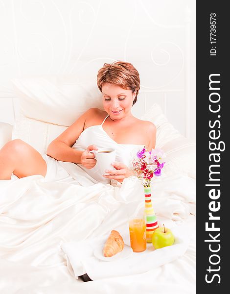 Beatiful woman having breakfast in white bed. Beatiful woman having breakfast in white bed