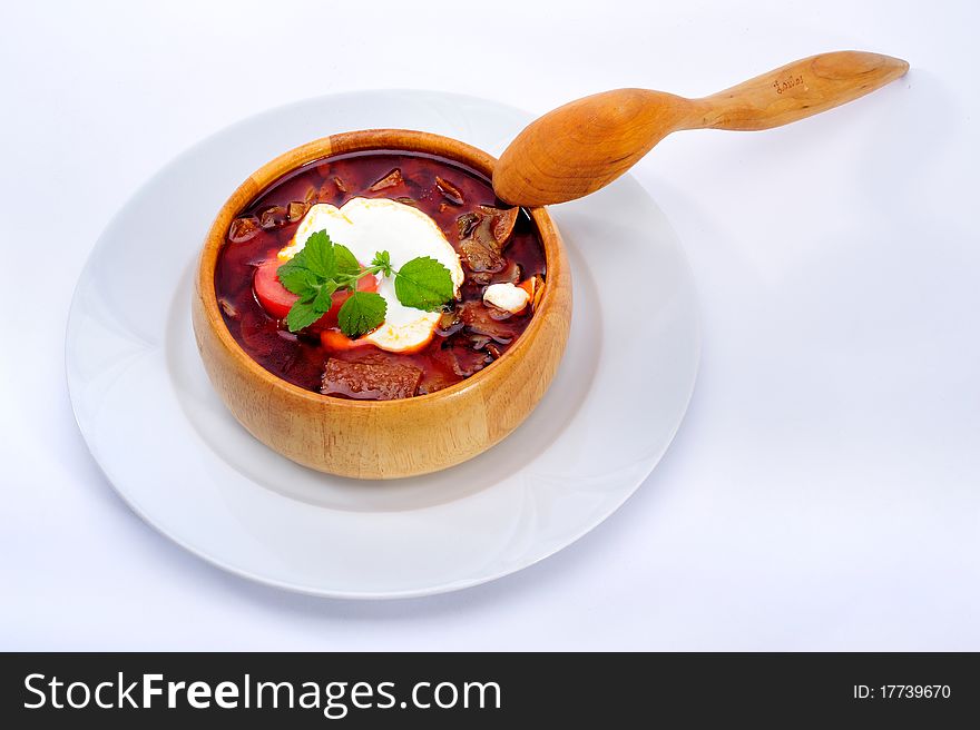 Soup with sour cream in wood plate with spoon. Soup with sour cream in wood plate with spoon