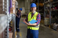 Warehouse Manager Writing On Clipboard In A Large Warehouse Royalty Free Stock Images