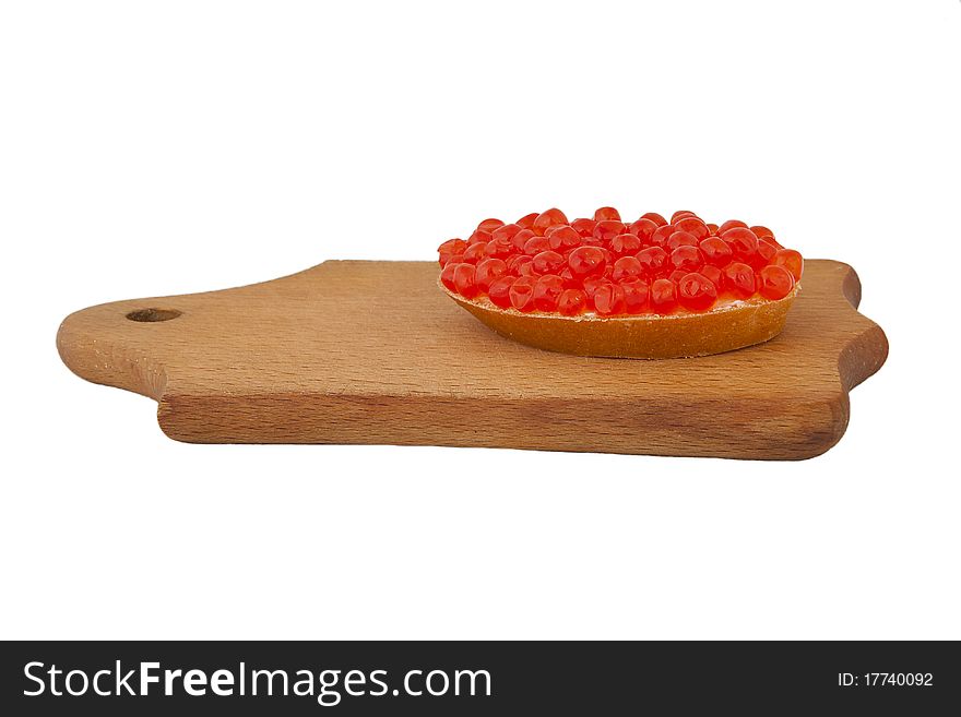 Bread and red caviar on wooden plank
