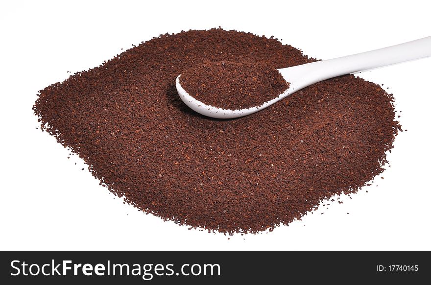 Picture of the ground coffee with a spoon for coffee on a white background