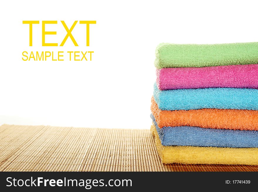 Lots of colorful bath towels stacked on each other. Isolated