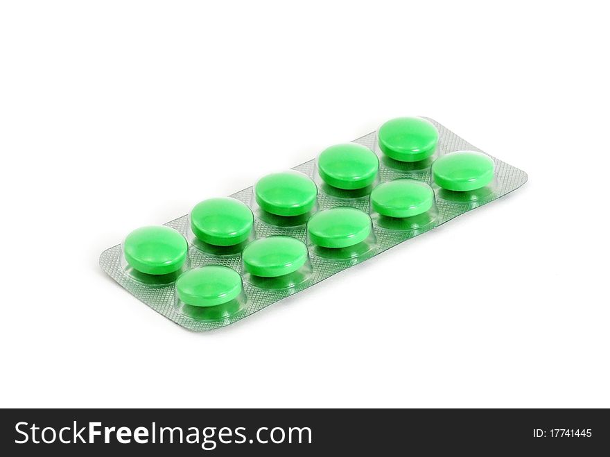 Green pills in blister pack against a white background