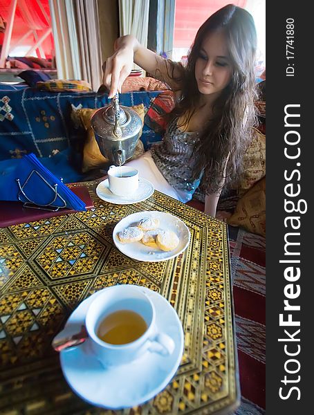 Beautiful Asian girl drinking tea in the national Asian interior