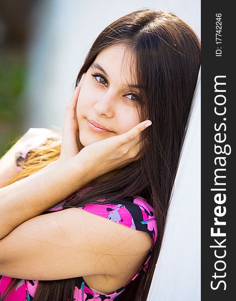 Beautiful Asian girl in pink dress on a background of white stone wall