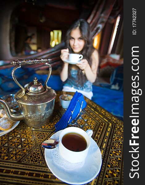 Beautiful Asian girl drinking tea in the national Asian interior