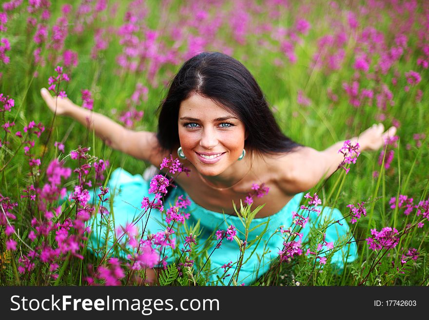 Woman on pink flower field close portrait