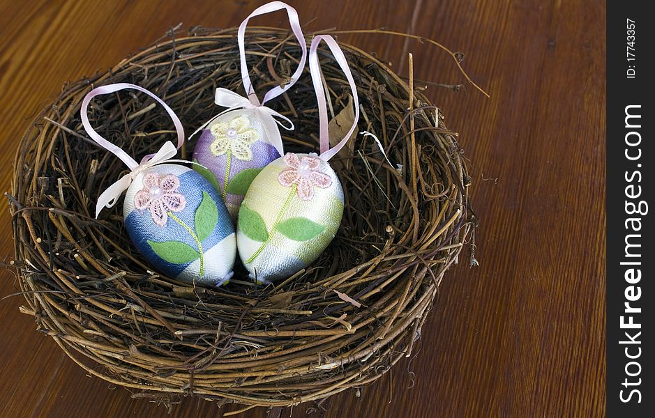 Easter eggs Decorated with yarn in a nest on a wooden table. Easter eggs Decorated with yarn in a nest on a wooden table