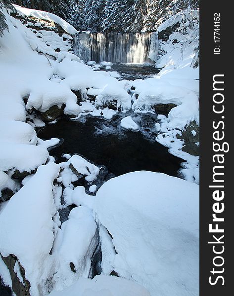 Waterfall and lots of snow on winter stream