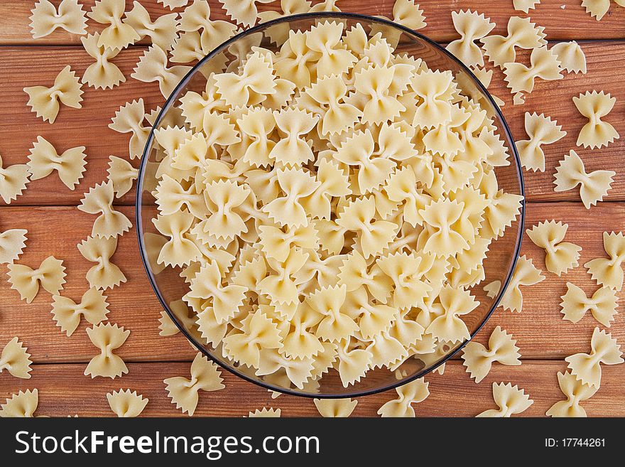 Raw farfalle in glass plate top view. Raw farfalle in glass plate top view