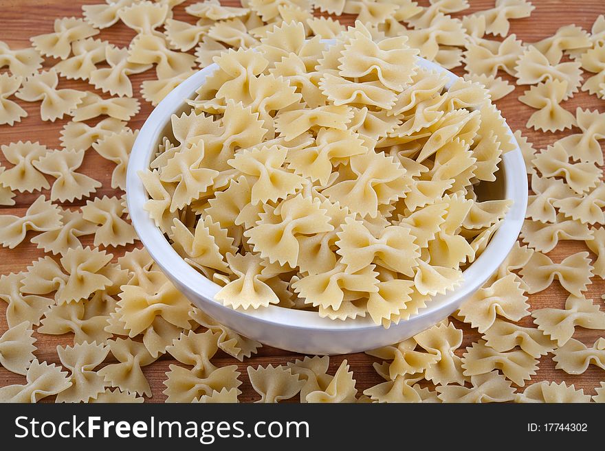 Raw pasta in white bowl