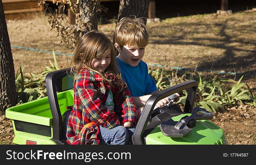 Girl And Boy Riding In A Small Car.