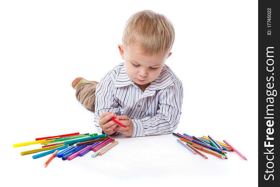 A cute boy with markers and pencils. isolated on a white background