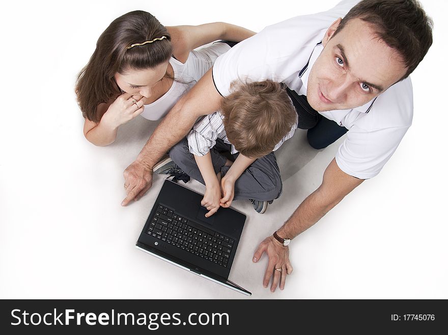 Young family lying on a floor with the computer on white isolation. Young family lying on a floor with the computer on white isolation