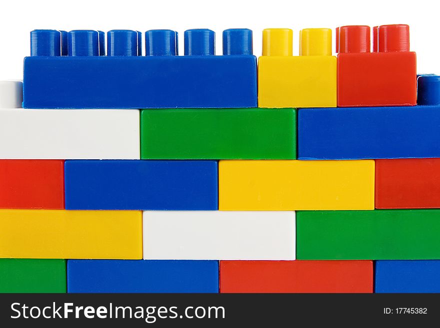 Standing wall assemble of colorful plastic bricks isolated on white background. Standing wall assemble of colorful plastic bricks isolated on white background