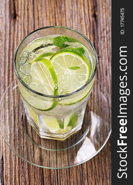 Glass of cold drink with slices of lime