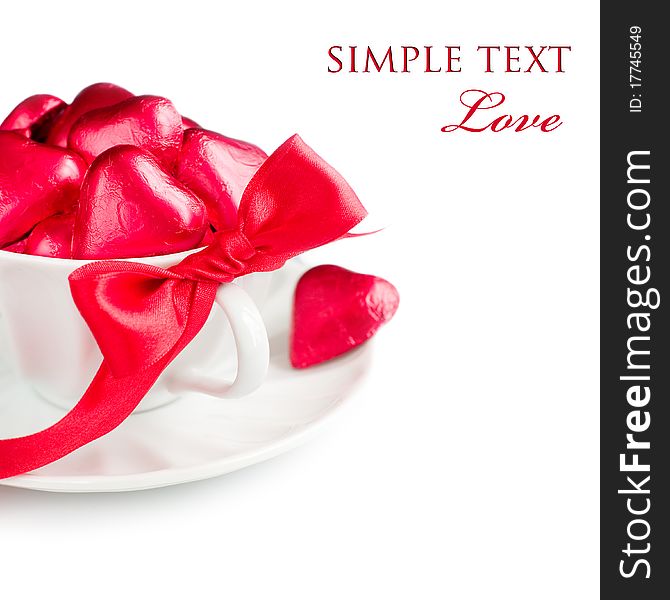 White cup with red chocolate hearts and ribbon with sample text. White cup with red chocolate hearts and ribbon with sample text