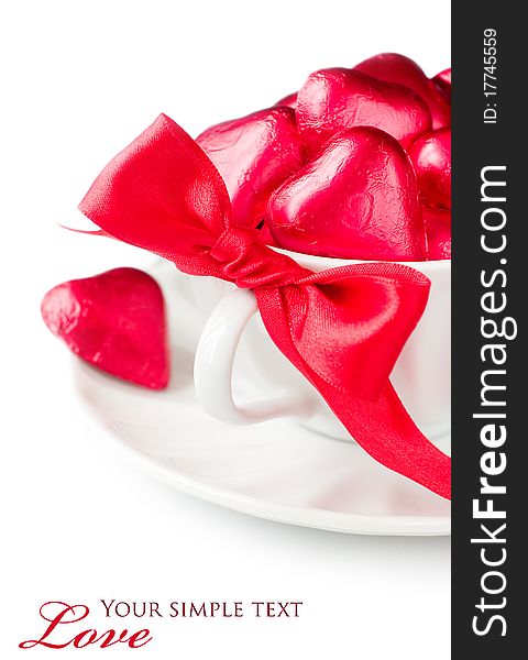 White cup with red chocolate hearts and ribbon with sample text