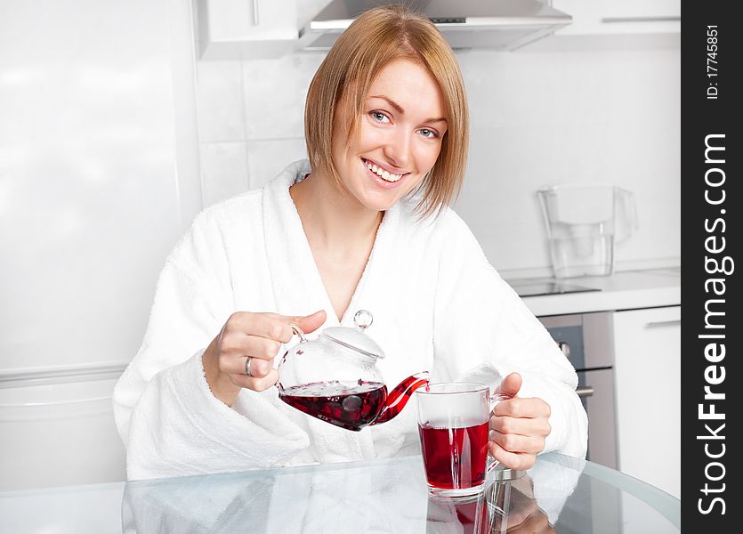 Beautiful happy young woman drinking tea at home in the morning