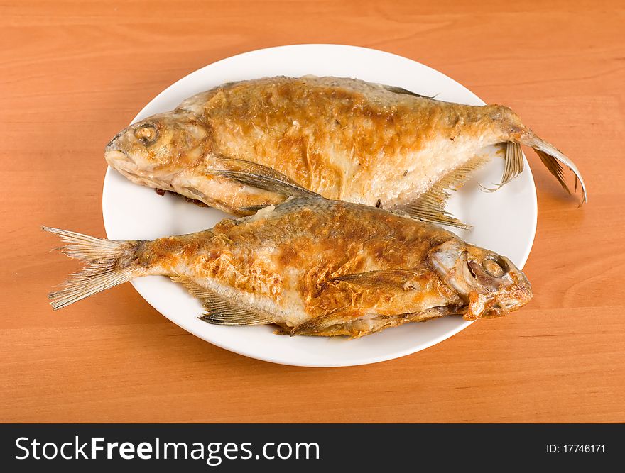 Roasted bream on the plate on a wooden table. Roasted bream on the plate on a wooden table