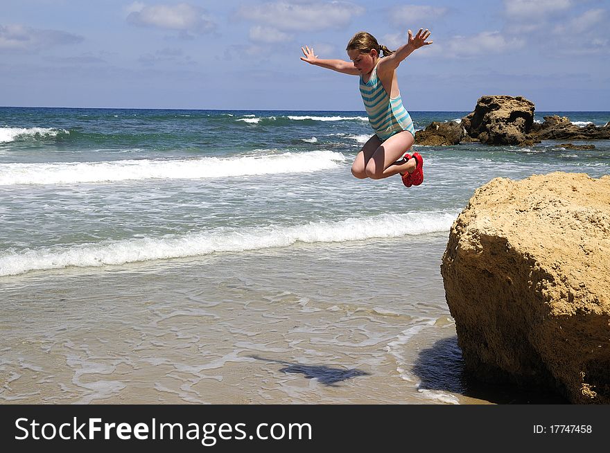 Jump girl in swimsuit with stone in water