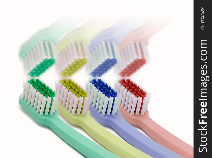 Four colored toothbrushes and its reflection