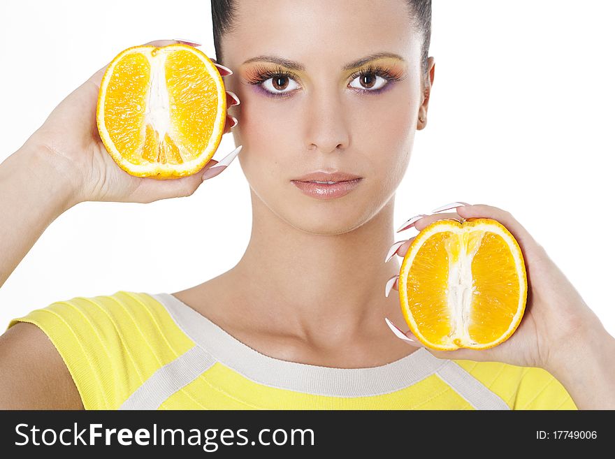 Young beautiful woman holding two halves of orange
