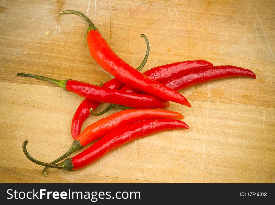 Red Thai cayenne chili peppers on a wooden cutting board. Red Thai cayenne chili peppers on a wooden cutting board