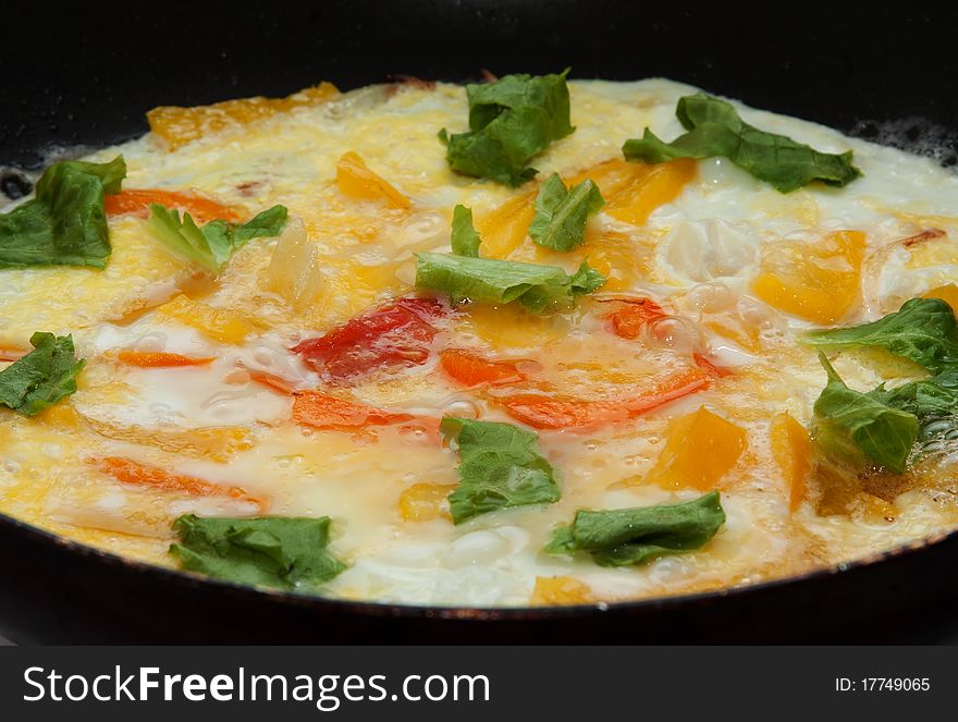 Scrambled eggs with vegetables on a omelet pan