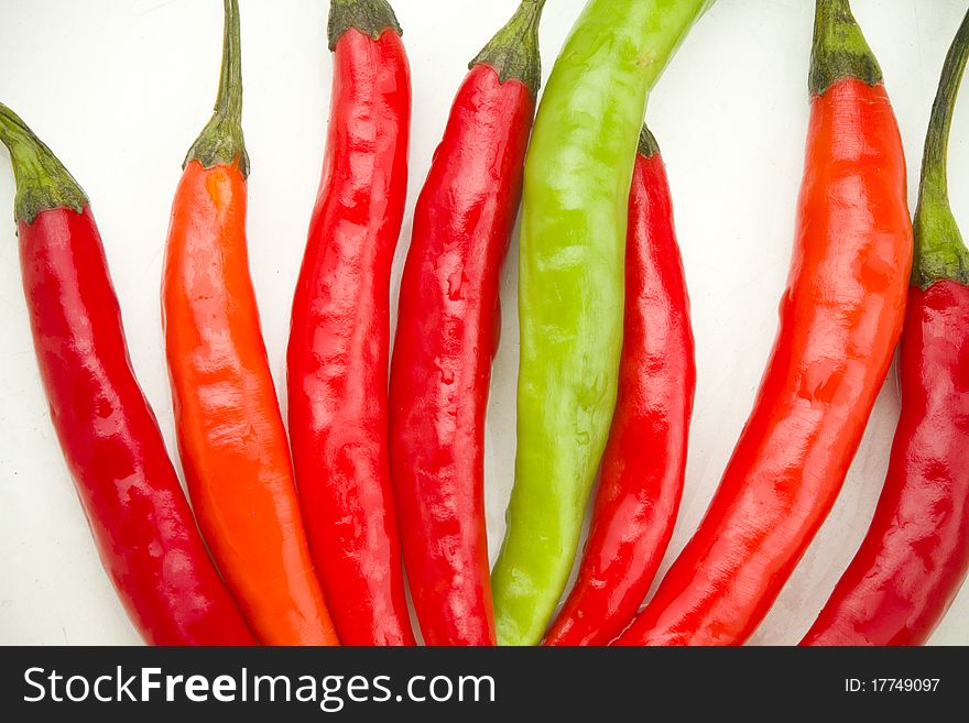 A colorful row of red and green spicy chili peppers on a white background. A colorful row of red and green spicy chili peppers on a white background