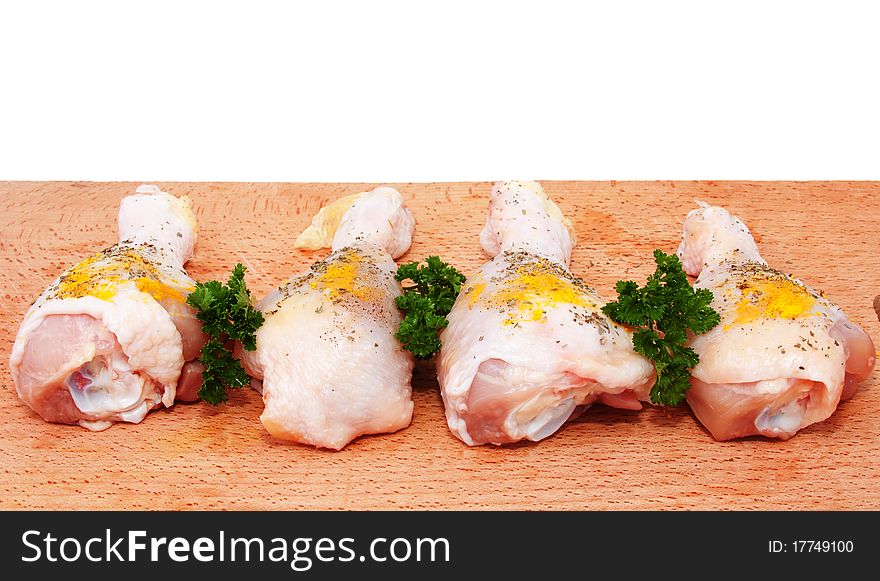 Raw chicken drumsticks with spices on a cutting board. Raw chicken drumsticks with spices on a cutting board