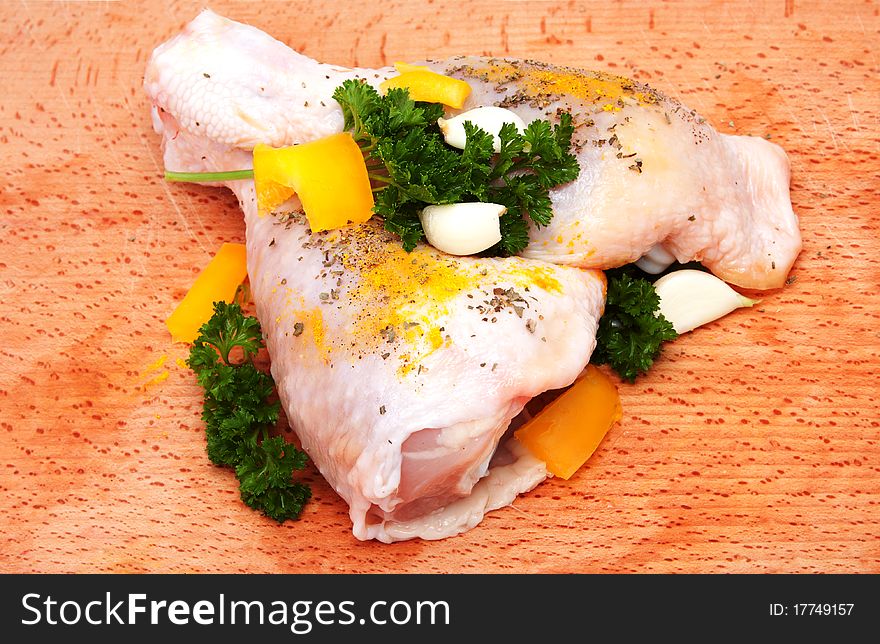 Two raw chicken legs with herbs and garlic
