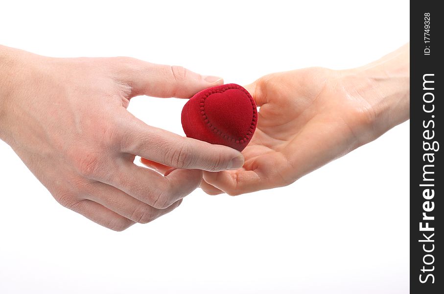 Man's hand expanding red velvet heart-shaped box to woman's hand; isolated on white. Man's hand expanding red velvet heart-shaped box to woman's hand; isolated on white