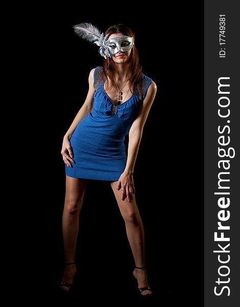 Young woman in mask and dress on black background