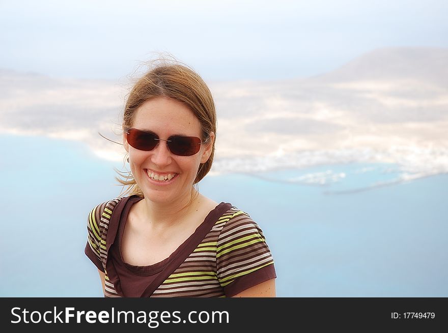 Young woman in Lanzarote with the small island of La graciosa in the background