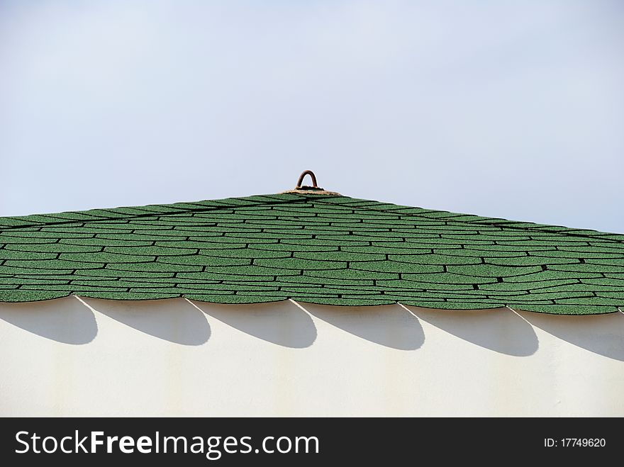 Architectural detail of a colorful roof with patterns of shadow against clear sky. Architectural detail of a colorful roof with patterns of shadow against clear sky