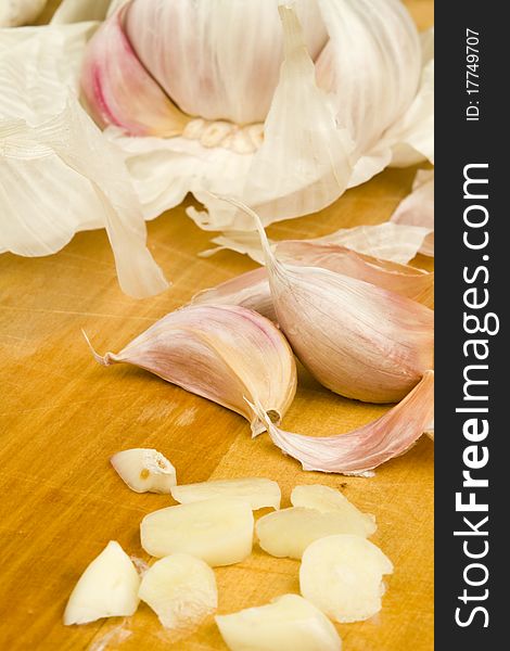 Freshly cut garlic cloves on a wooden table surface. Freshly cut garlic cloves on a wooden table surface