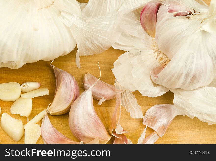 Freshly cut organic garlic cloves on a wooden table surface